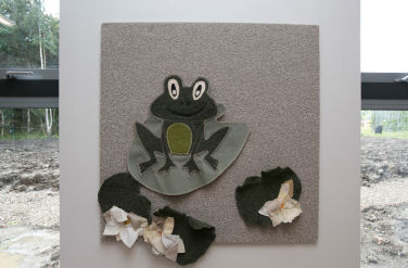 a fabric pinboard with a frog on a lily pad made from fabric