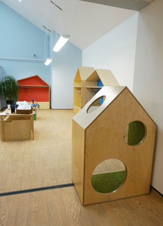 a house shaped nook for children to sit in, has two circles cut into the back and one in the roof to look out of