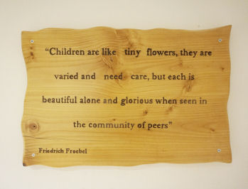 a sign saying "children are like tiny flowers, they are varied and need care, but each is beautiful alone and glorious when seen in the community of peers"